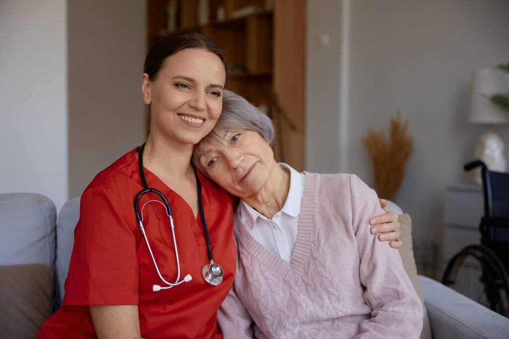 A caregiver embracing an older woman at home, both smiling
